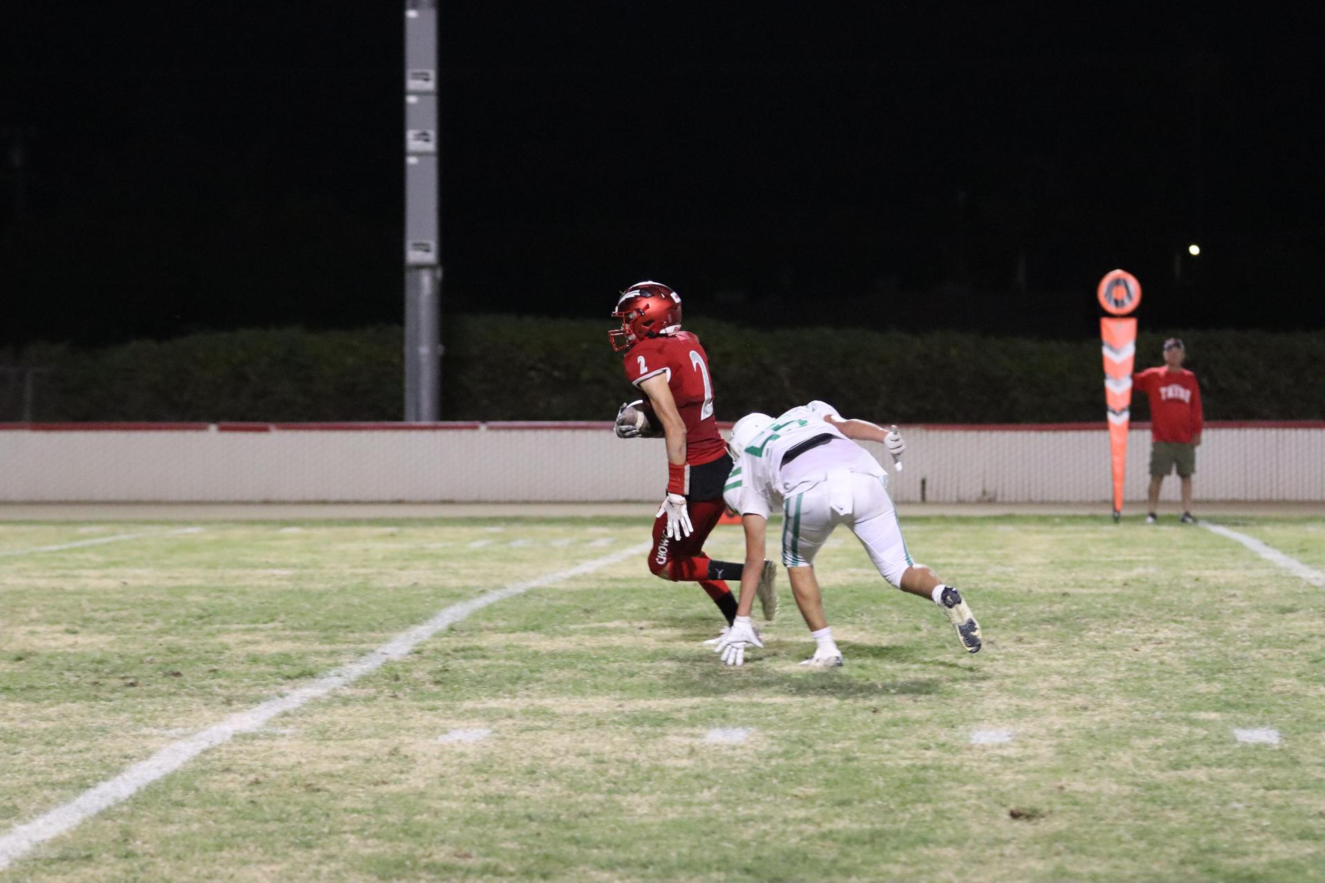 varsity football players in action against Riverdale