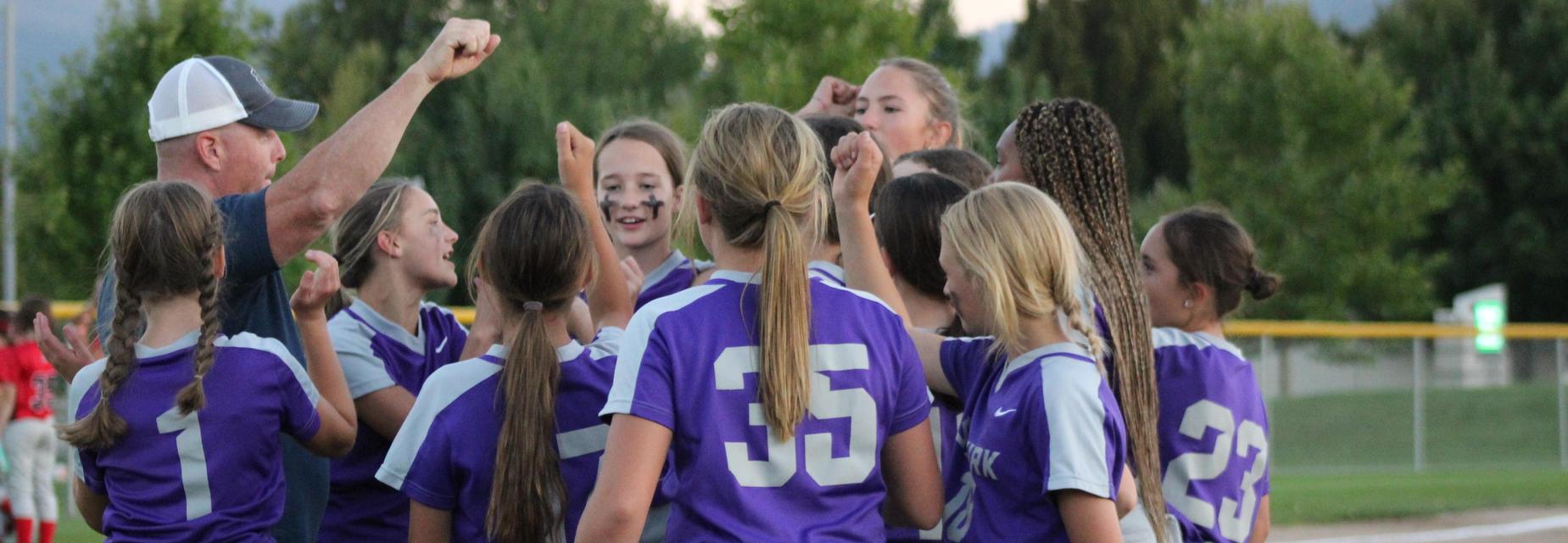 Girls softball team huddling up and cheering