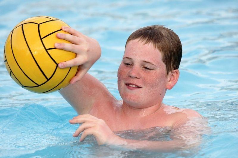 Child learning how to control a ball in water