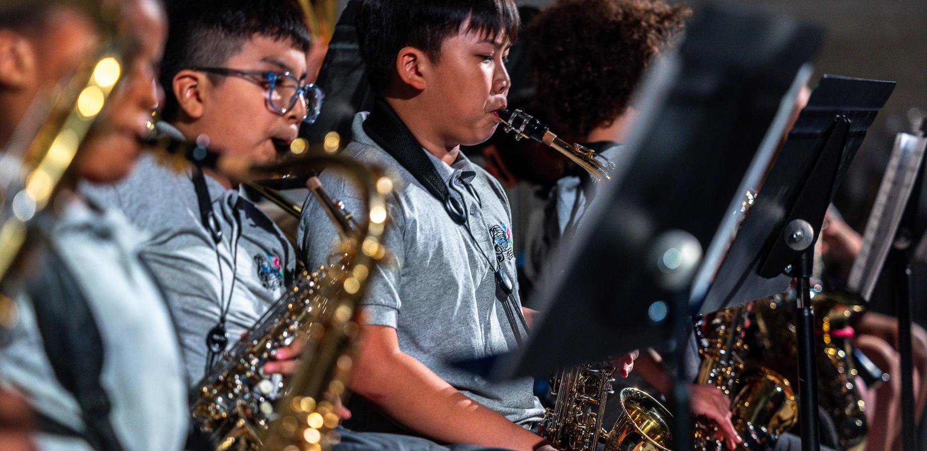 Children playing saxophones in a music performance
