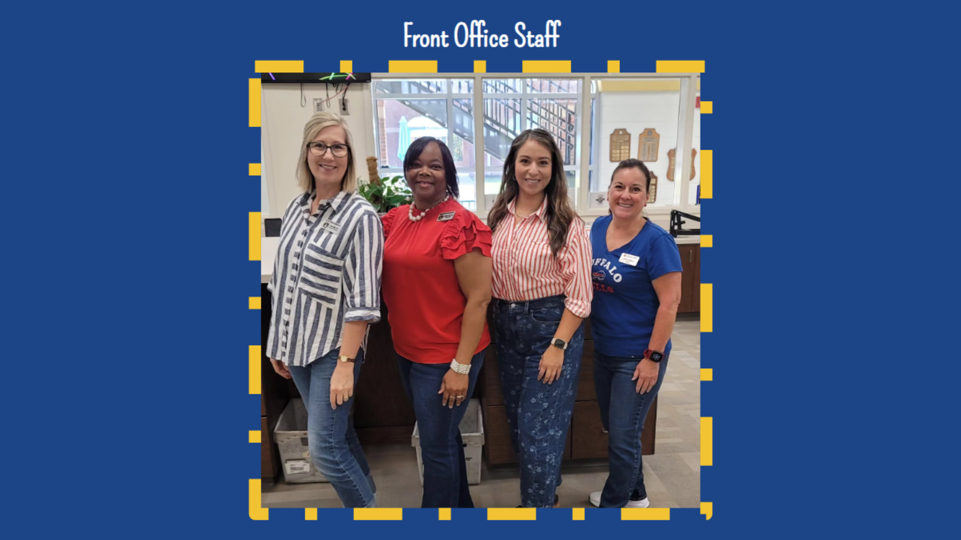Front office staff posing together in a welcoming setting.