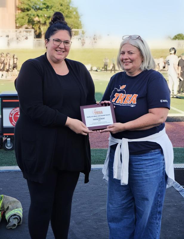HS teacher Cary Saxton presents the Above and Beyond Award to High School teacher Tricia Rickert.