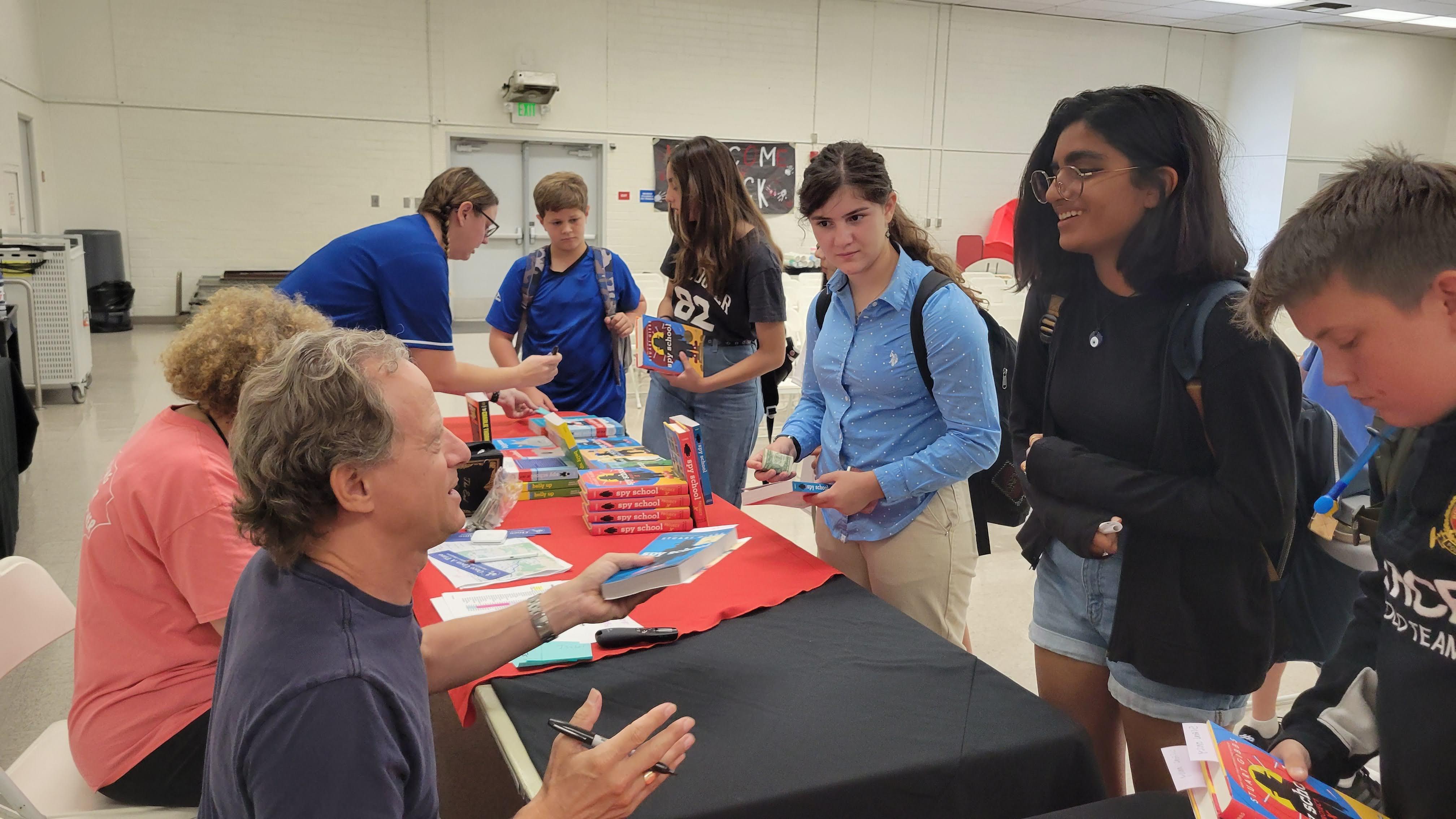 Students line up to have their books signed by author Stuart Gibbs