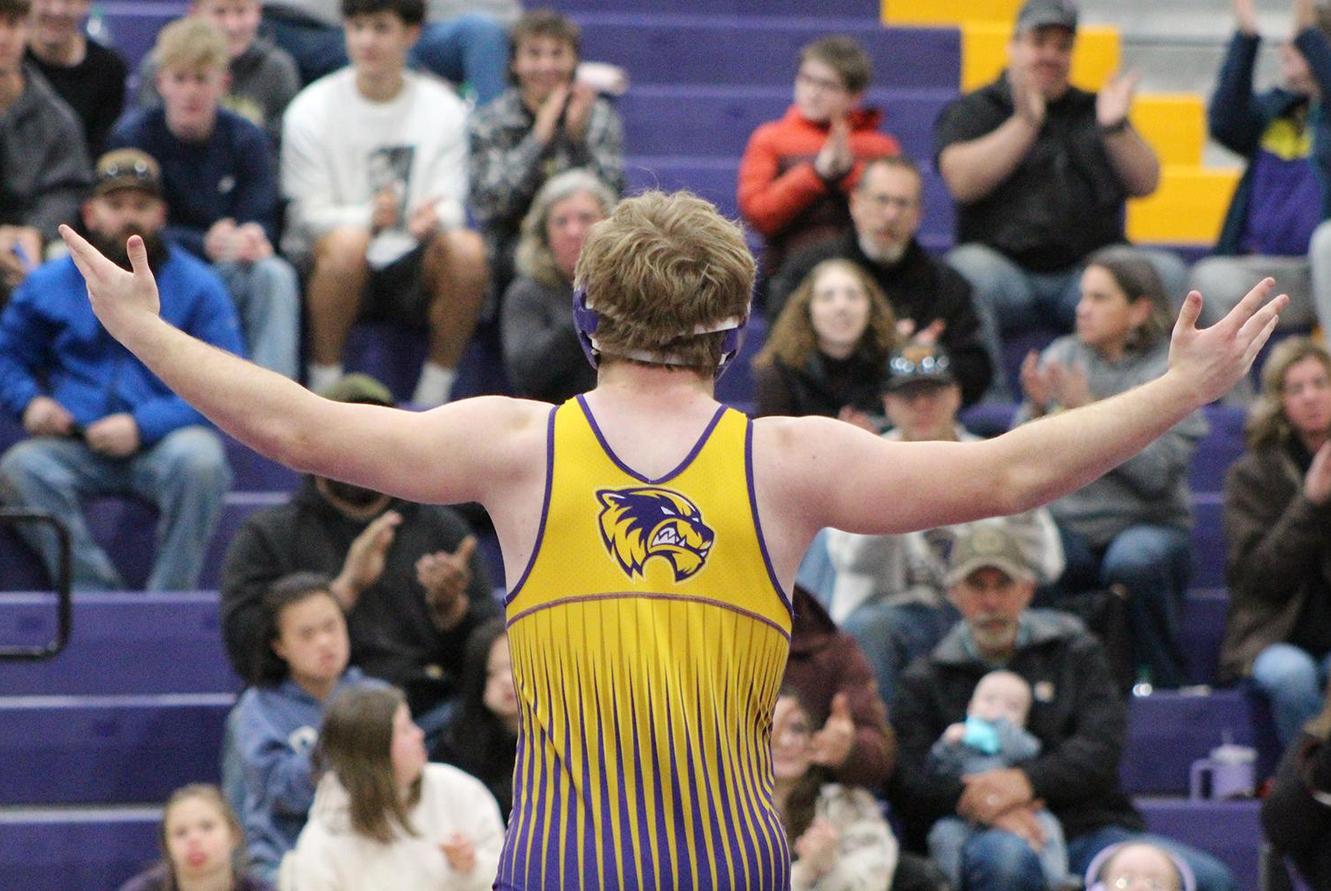 A wrestler calls on the crowd to cheer.