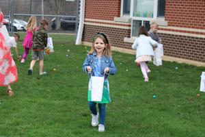 girl holding bag of eggs standing in the grass