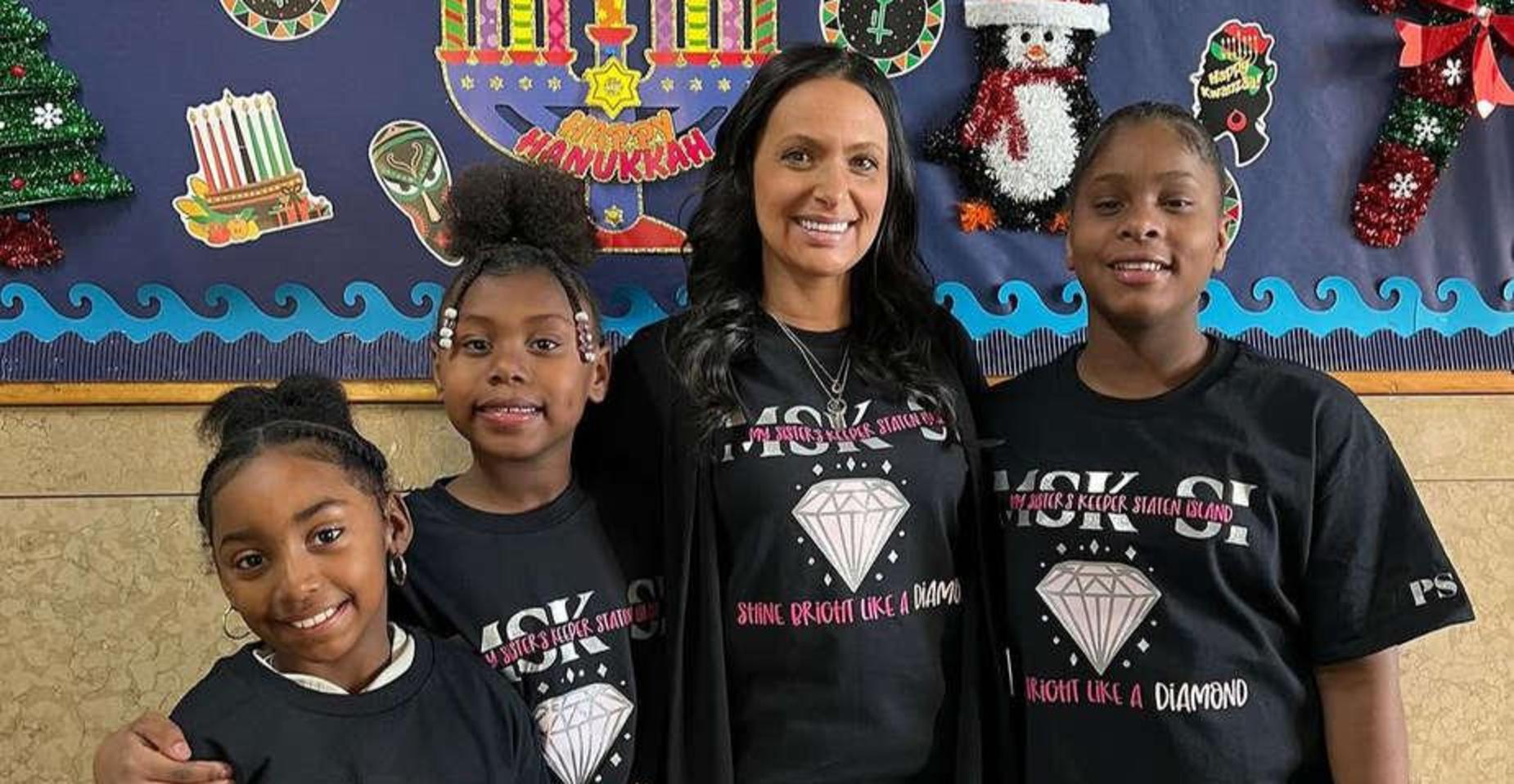A woman and three girls in matching shirts with a diamond graphic and inspirational text.