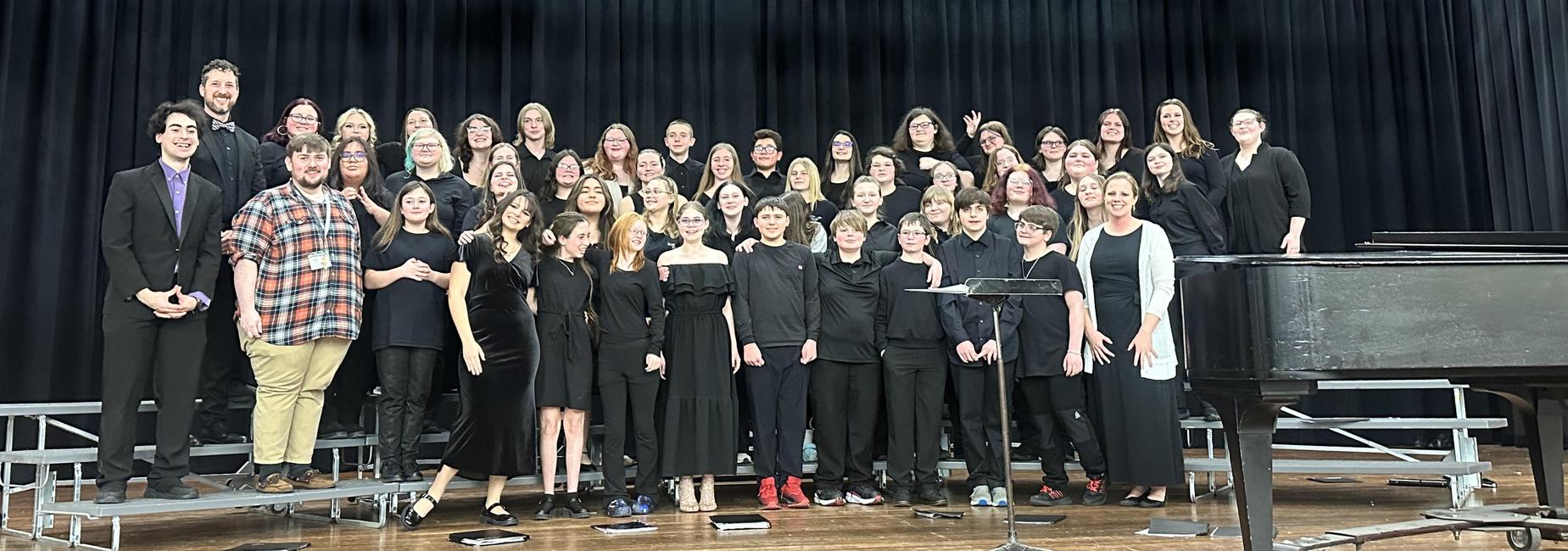 All county band students standing on a riser posing for pictures.