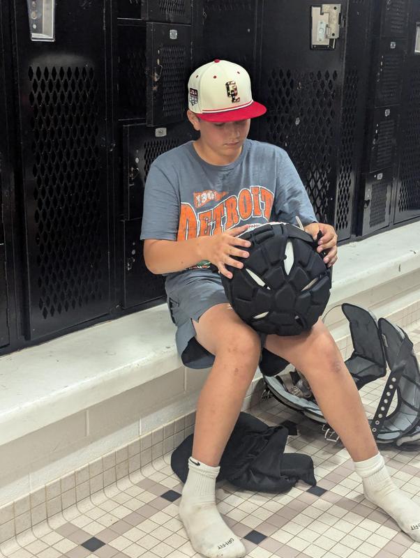 A student adjusts the Guardian Cap over his regular helmet.
