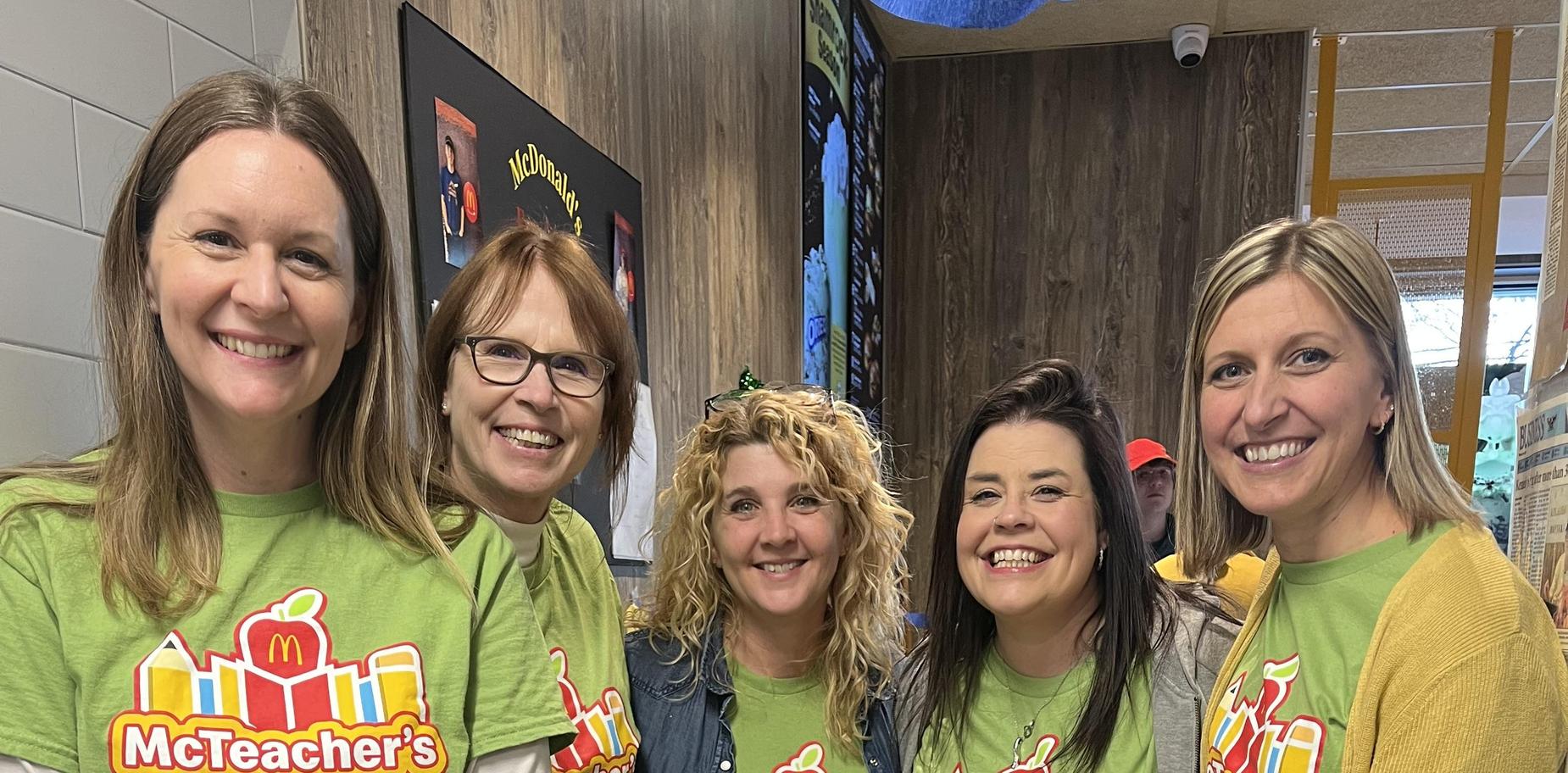 Five people in green shirts promote McTeacher's Night.