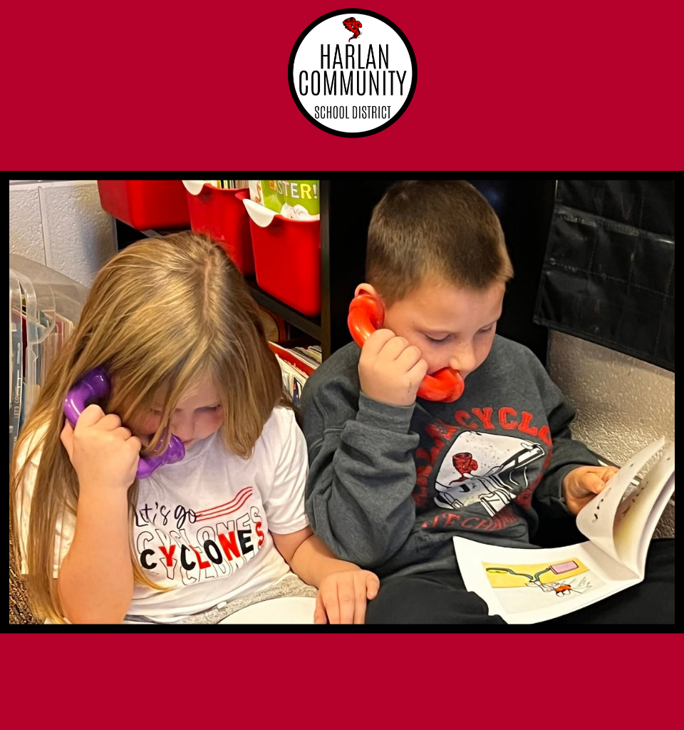 Two children using toy phones while reading books.