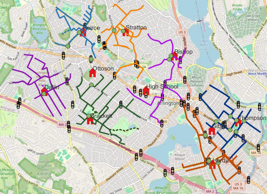 District-wide map of Arlington, MA showing all elementary, middle, and high schools with their walking routes color-coded by school: Peirce and Thompson (blue), Stratton and Hardy (orange), Dallin and Bishop (purple), Brackett (green). Ottoson, Gibbs, and Arlington High School are shown as locations without dedicated routes. Green dots mark traffic supervisor posts and traffic light icons mark signalized intersections throughout