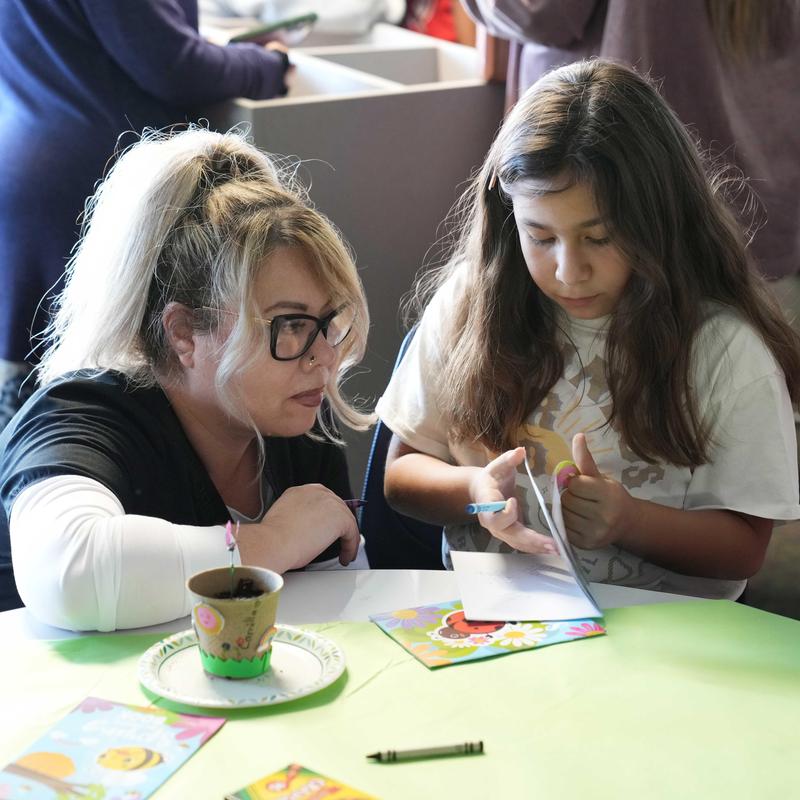 lady and girl working on a booklet