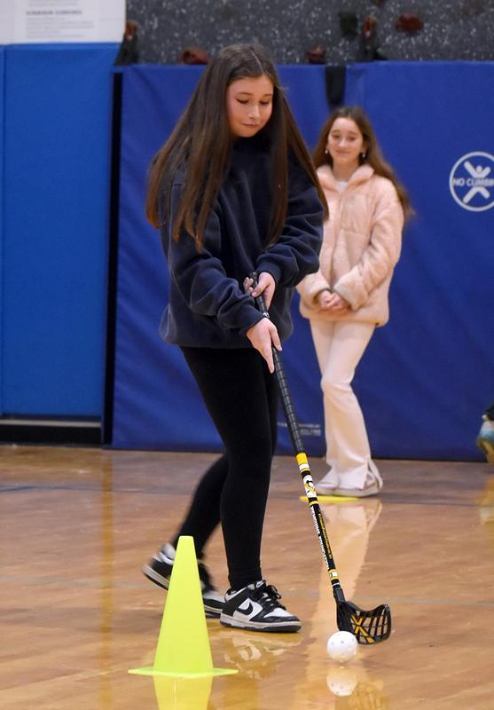 A person holding a stick with another person in the background