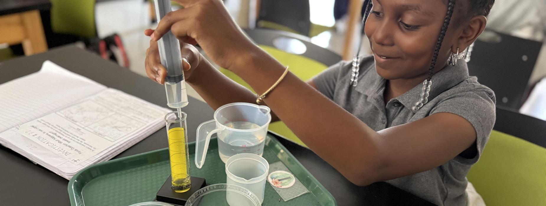 Child conducting a science experiment with colorful liquids and equipment.