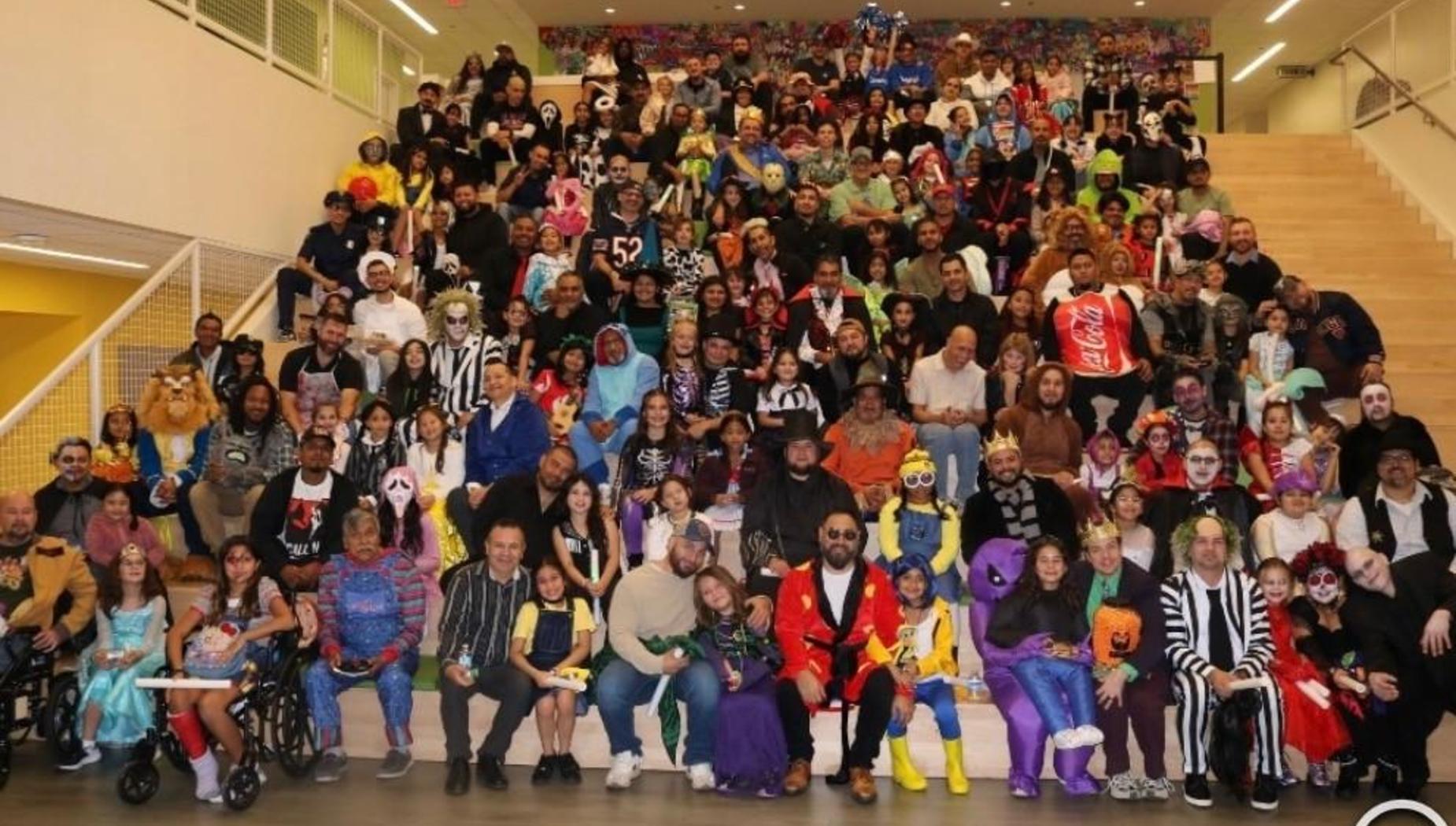 A large group of diverse people dressed in colorful costumes, gathered on a staircase.