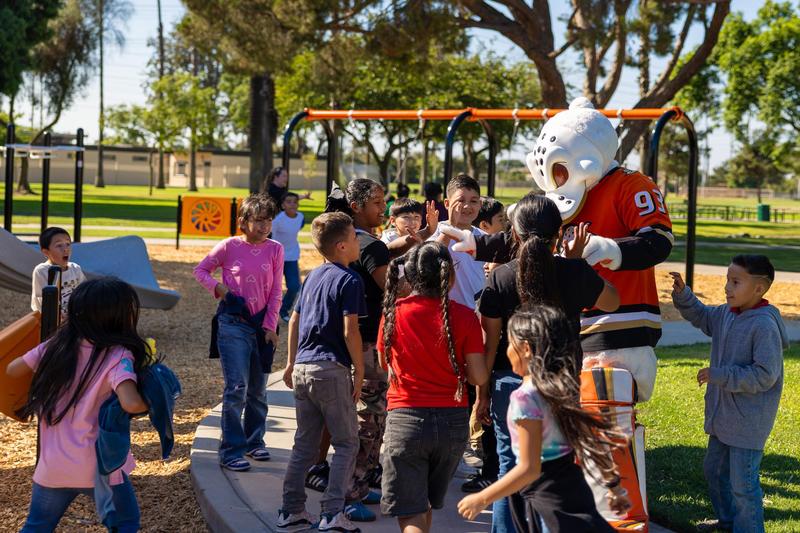 Wild Wing giving high-fives to excited students.