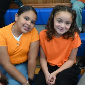Two students wearing orange shirts