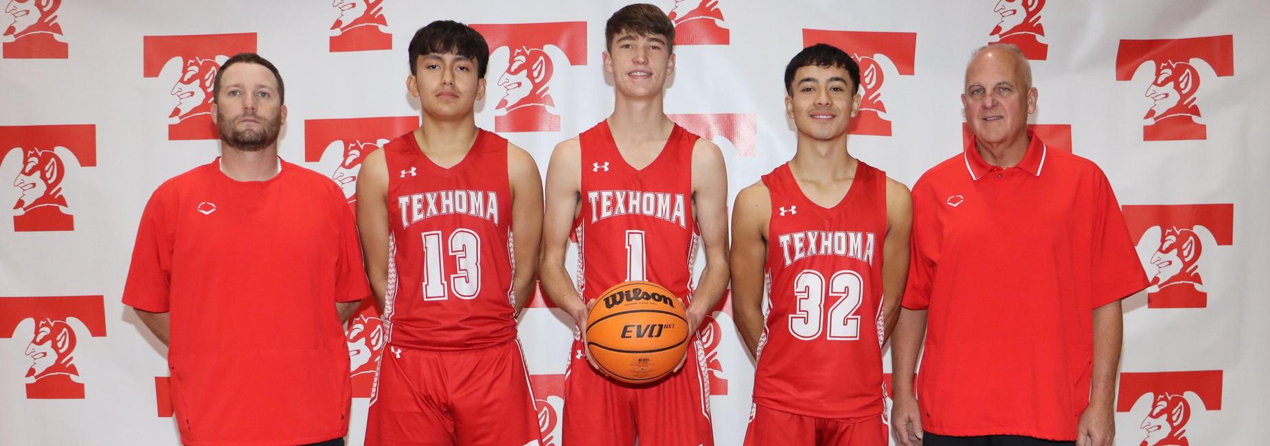 Male basketball players and coaches posing for a team photo with a basketball.