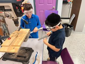 2nd grade boys sanding down their metal rods for the menorah.