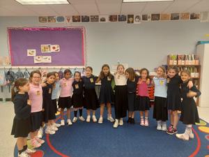 Second grade girls pose while wearing badges