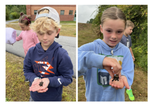 two student's holding baby snapping turtles