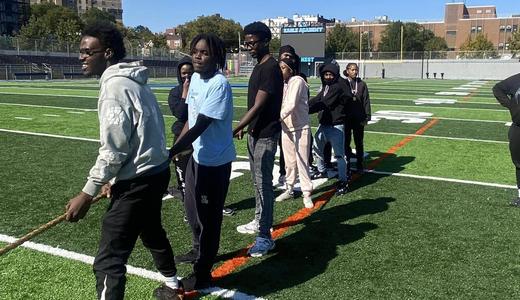 Group of young people participating in an outdoor activity on a sports field.