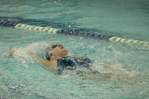 Girls swimmer does the backstroke