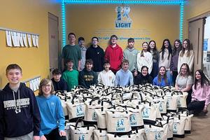 Penn Middle School student volunteers with the 125 finished totes that were donated to cancer patients