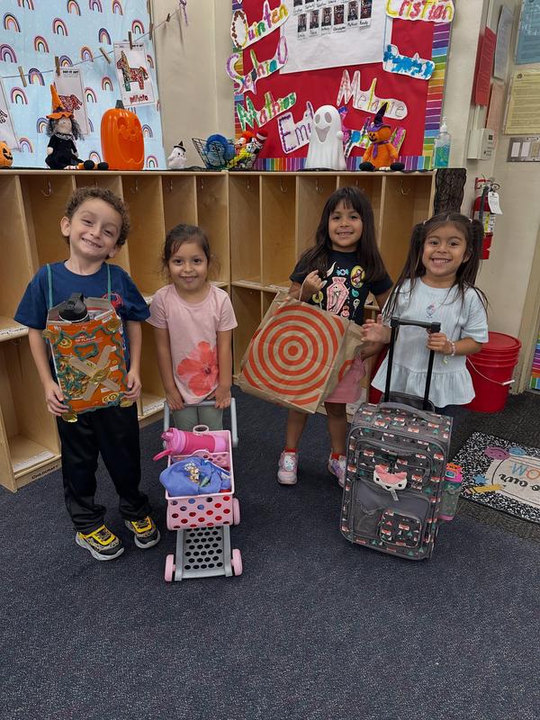 k12 students hold up their work proudly