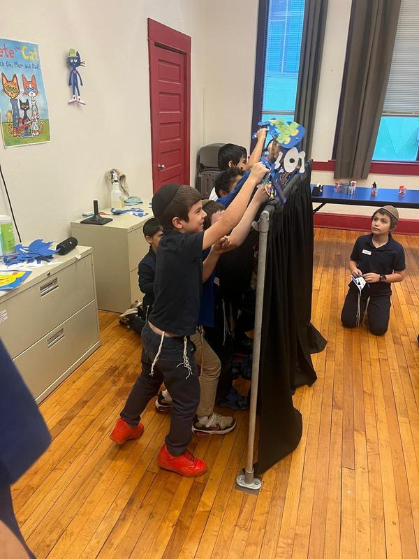 students performing their own puppet show.