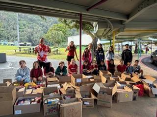 Students standin behind boxes of donated food.