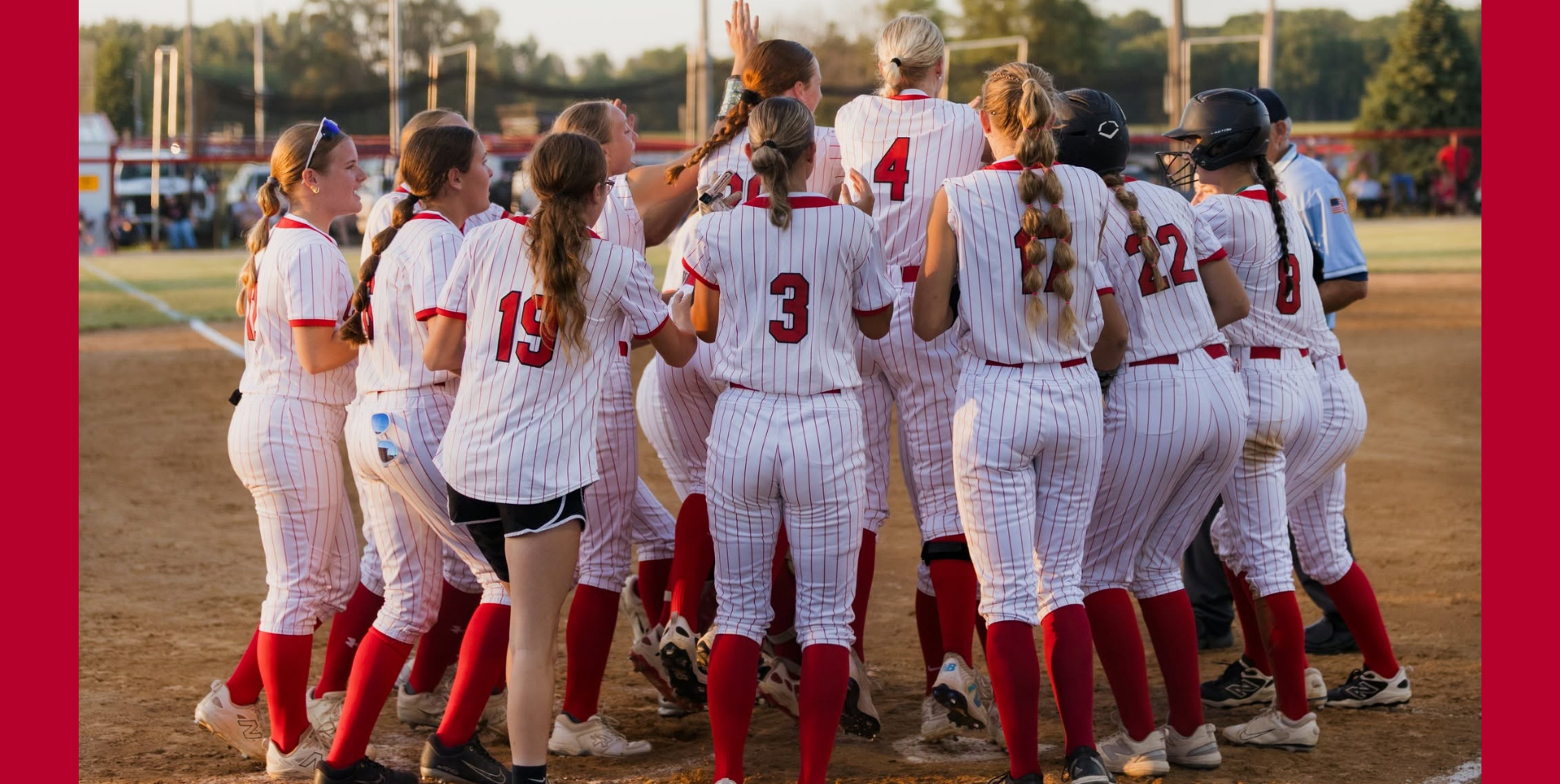 Cheerful girls' softball team celebrating a victory on the field.
