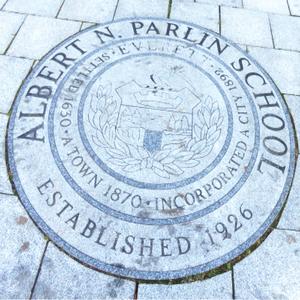 Stone seal of Albert N. Parlin School, established 1926, on pavement.