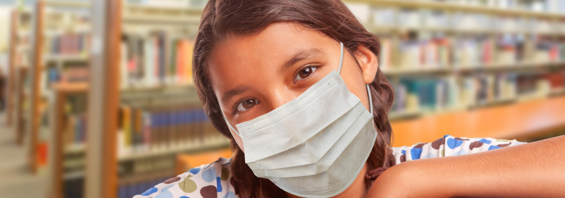 girl wearing face mask in library