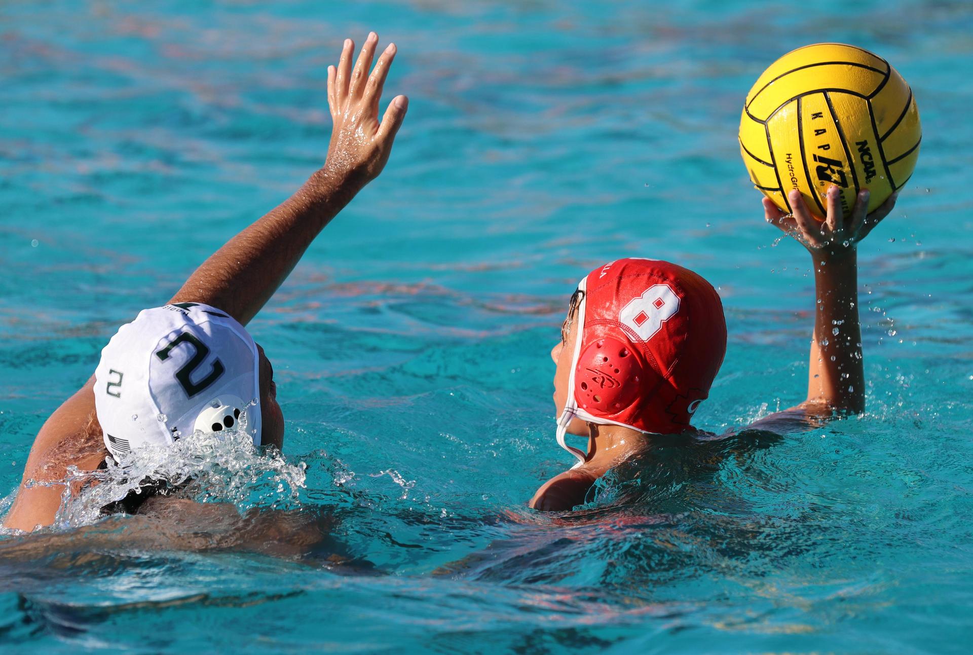 boys water polo players in action against hoover