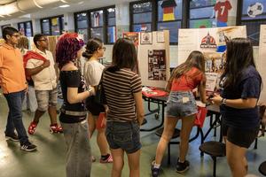 students in the cafeteria looking at a posterboard