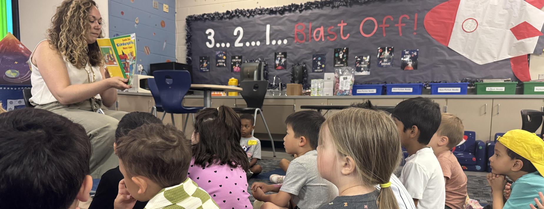 principal reading a book to a group of kids