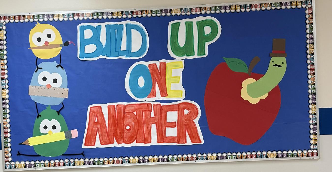 Colorful bulletin board displaying a positive message with cartoon characters.