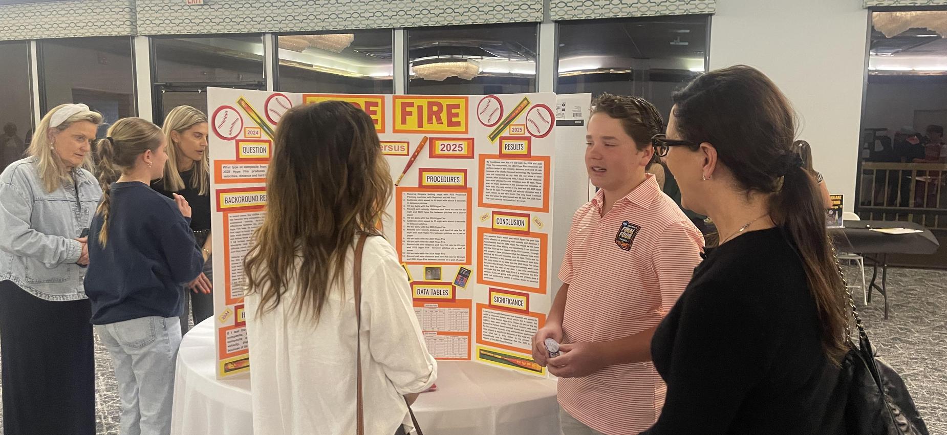 student  presenting science fair project to parents