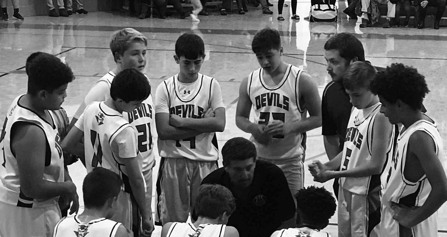 A picture of basketball team with coaches