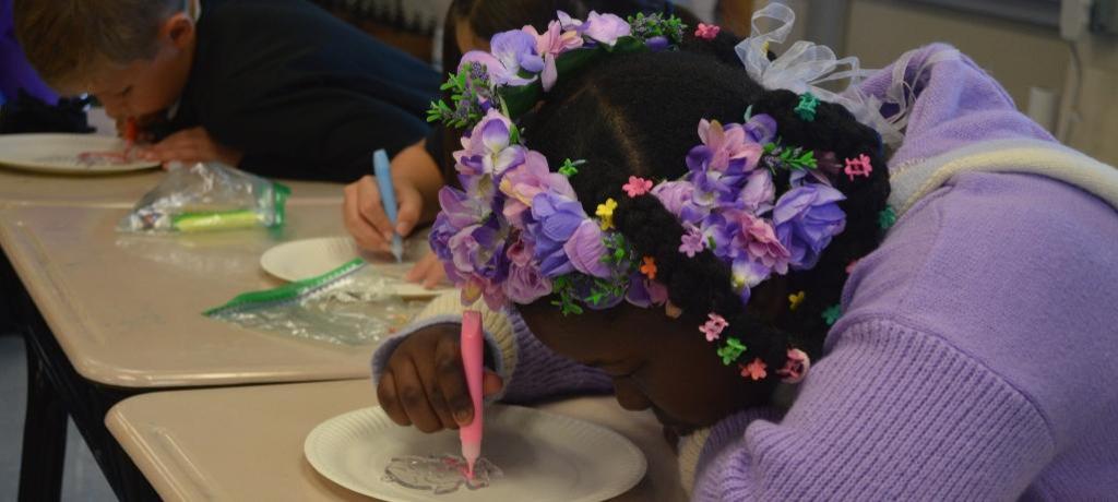 girl works on Halloween painting craft project