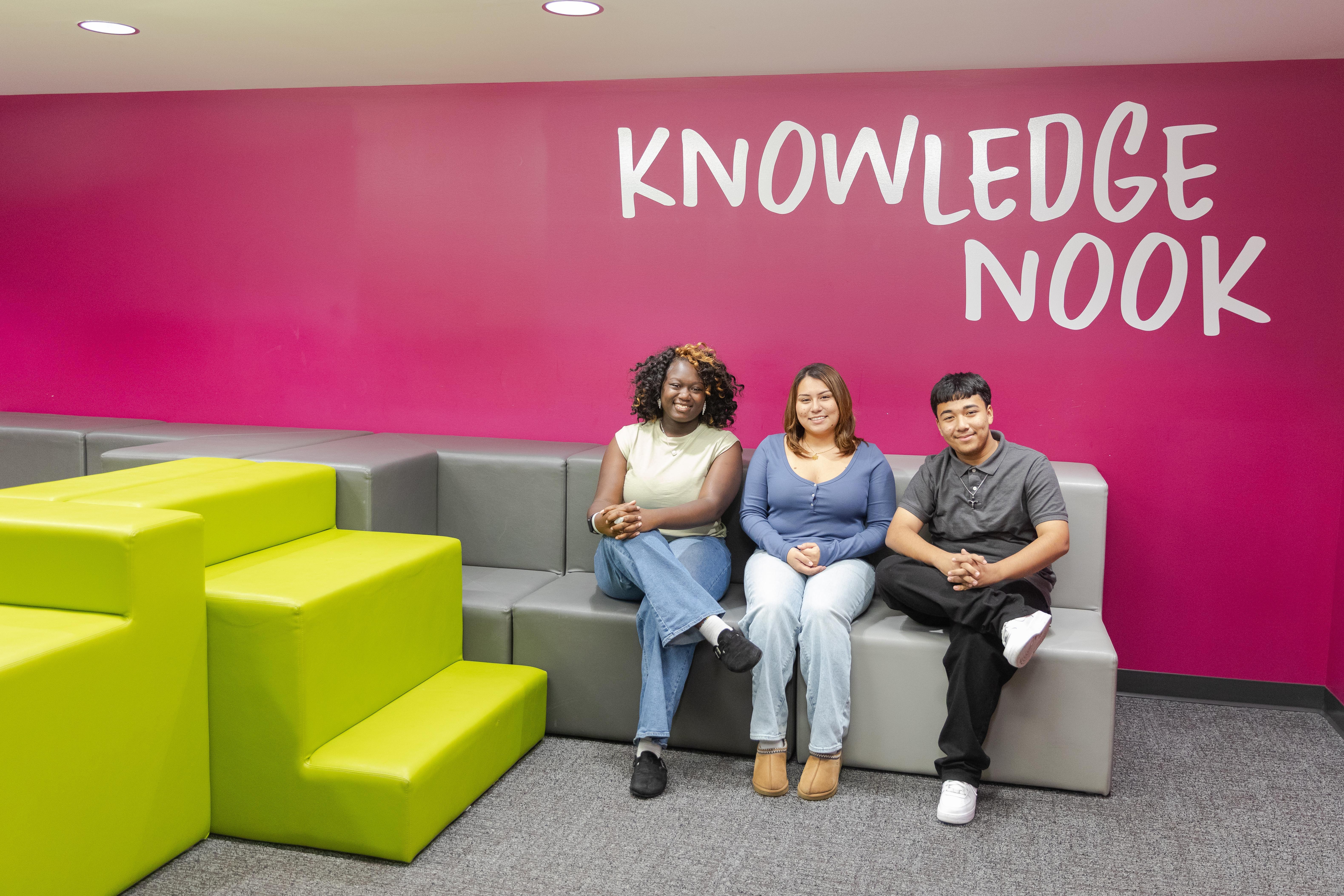 Three high school students sitting in Tenor Journal Square's new Knowledge Nook space.