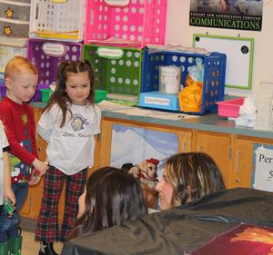 two preschoolers watching two middle schoolers