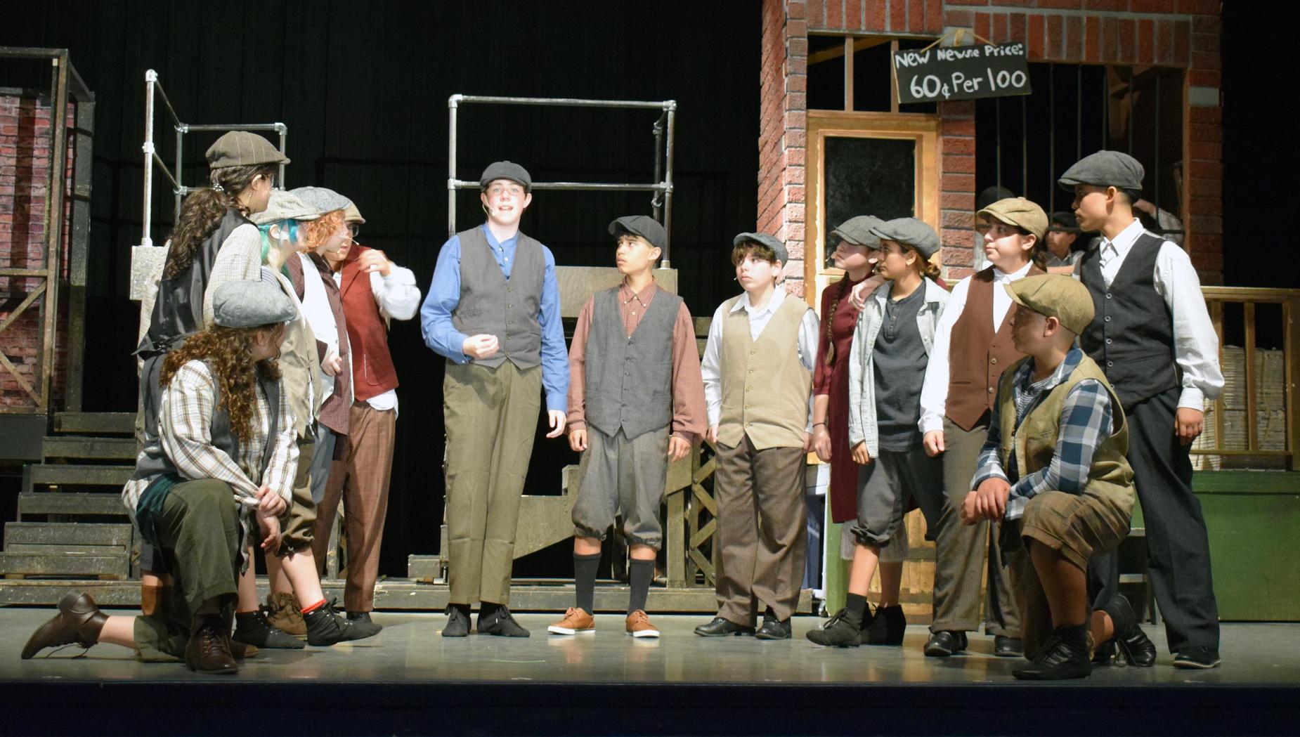 A stage performance with performers in historical costumes engaging in dialogue.