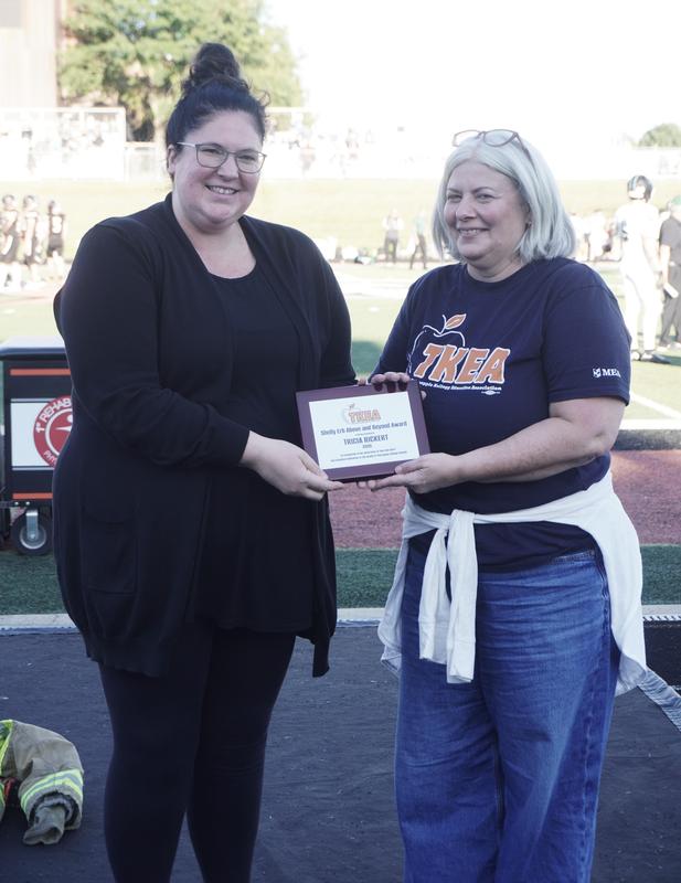 HS teacher Cary Saxton presents the Above and Beyond Award to High School teacher Tricia Rickert.