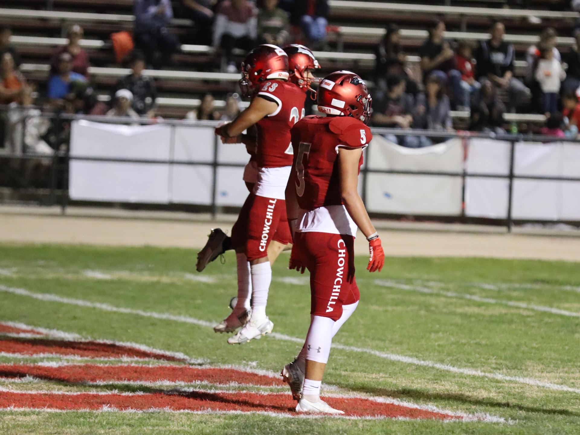varsity football players in action against Riverdale