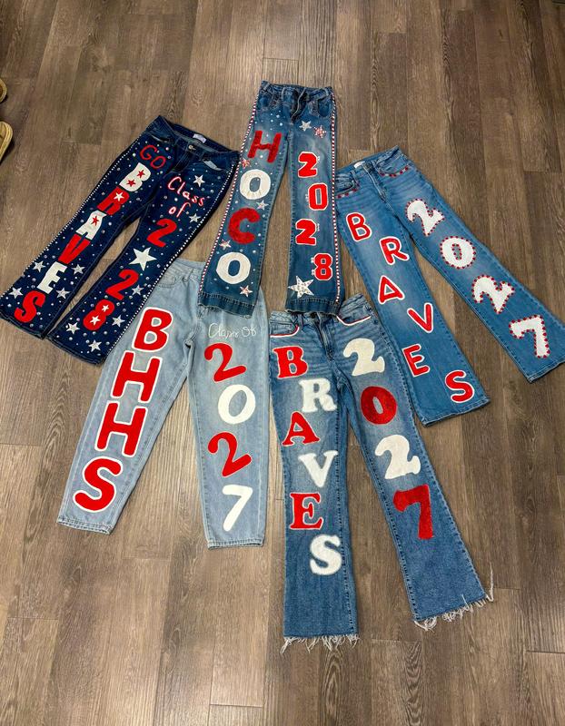 A collection of decorated jeans featuring various year numbers and team names.