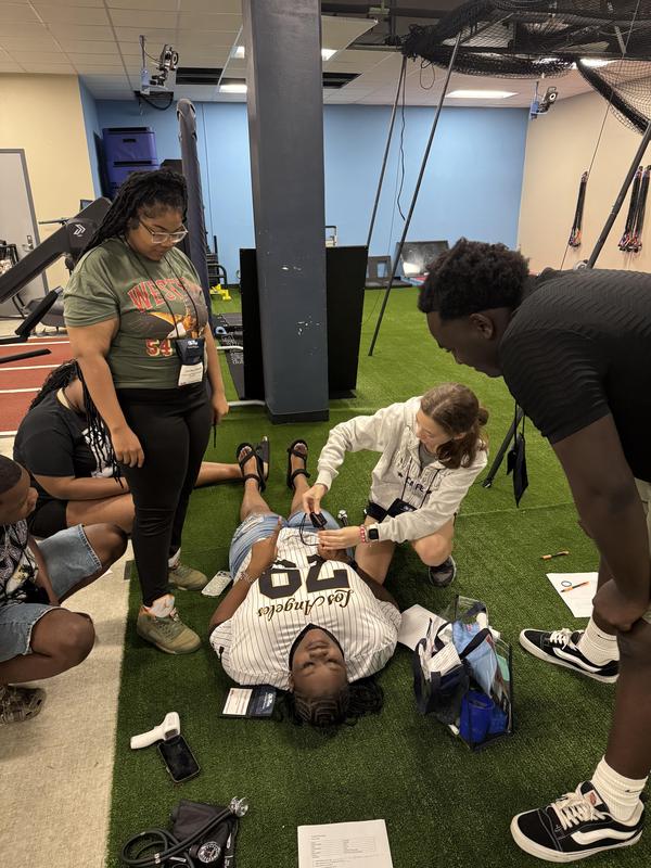 Students gathered around another student in a medical demonstration