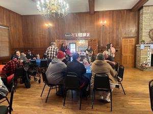 Wide angle of people sitting at tables at Community House