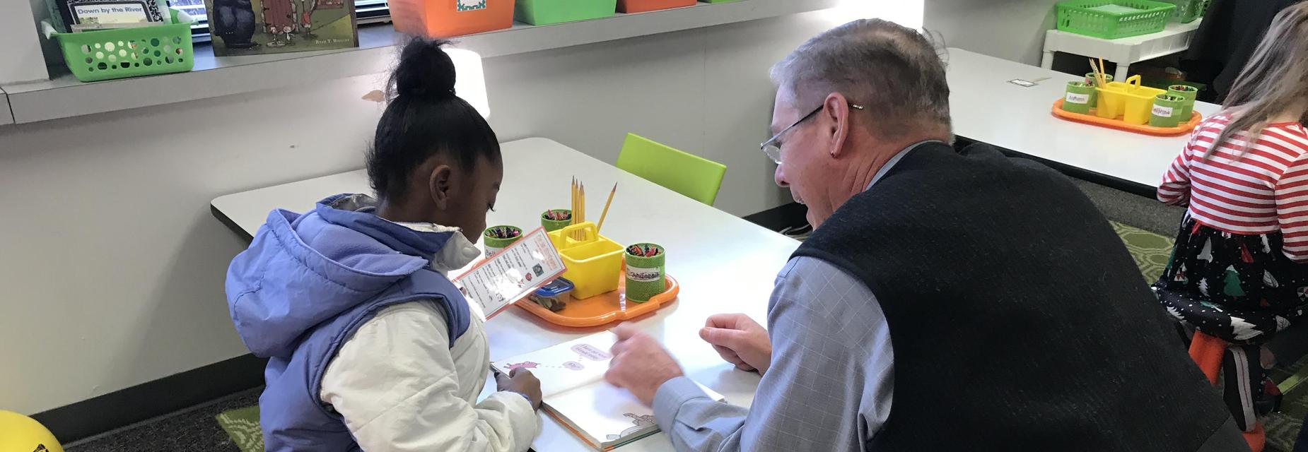 Student reading with Representative McCaslin